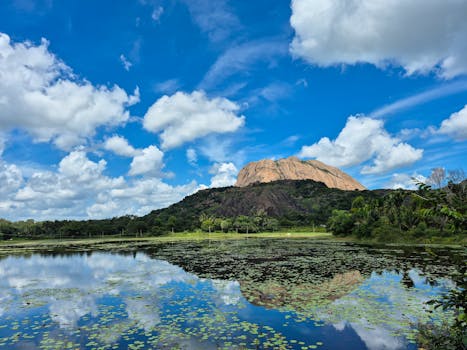 Breathtaking view of Savandurga Hill in Karnataka reflecting in a serene lake.